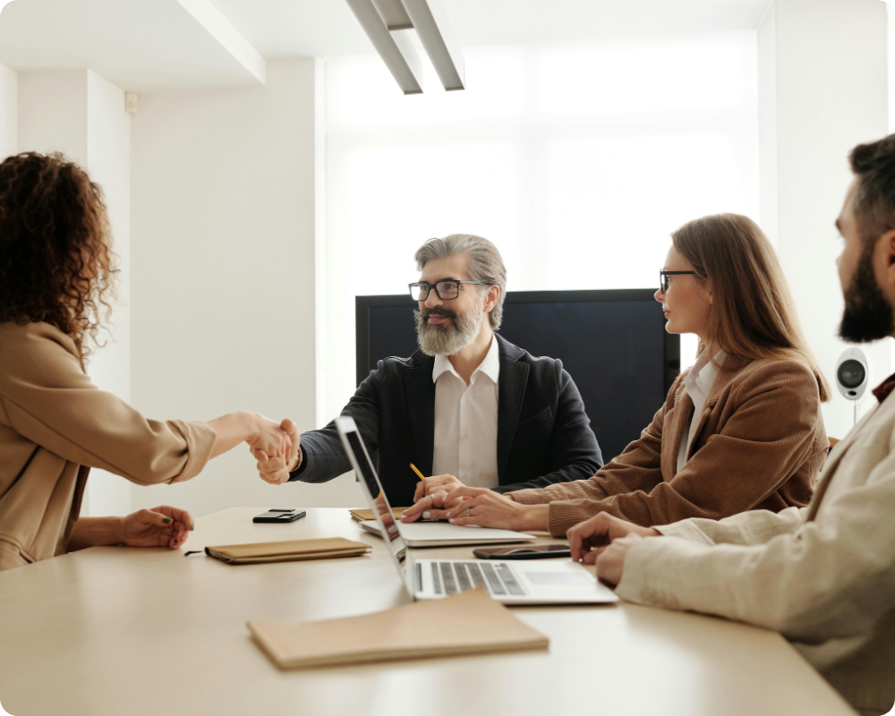 Business team shaking hands in a meeting, representing an HR compliance platform for Australian membership organisations and associations